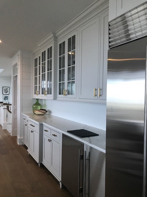 Design ideas for a large transitional l-shaped eat-in kitchen in Philadelphia with a farmhouse sink, beaded inset cabinets, grey cabinets, quartzite benchtops, white splashback, ceramic splashback, stainless steel appliances, medium hardwood floors, with island and orange floor.