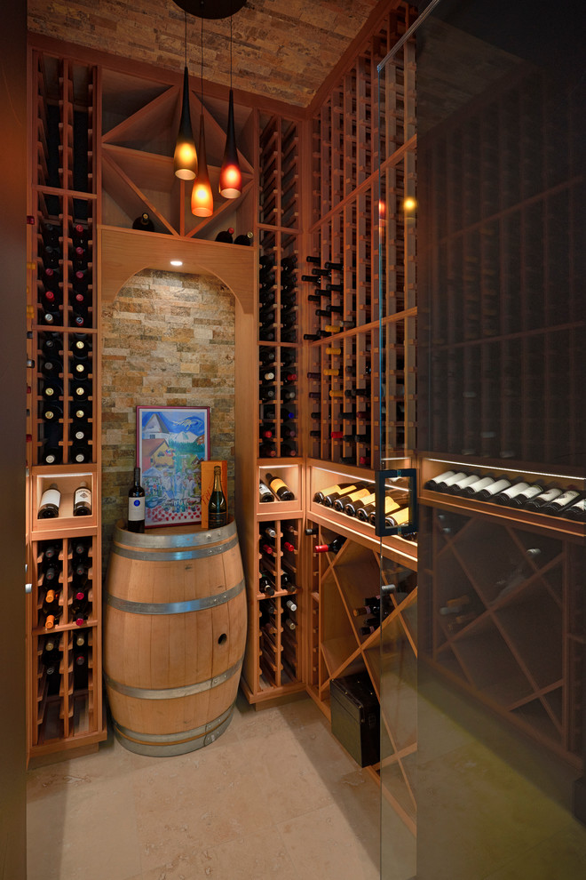 This is an example of a large modern wine cellar in Denver with travertine floors and storage racks.
