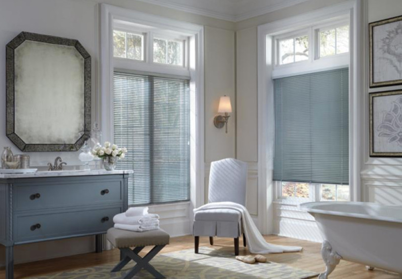 Photo of a large traditional master bathroom in Baltimore with flat-panel cabinets, blue cabinets, a freestanding tub, a two-piece toilet, gray tile, white tile, beige walls, light hardwood floors, a drop-in sink and marble benchtops.