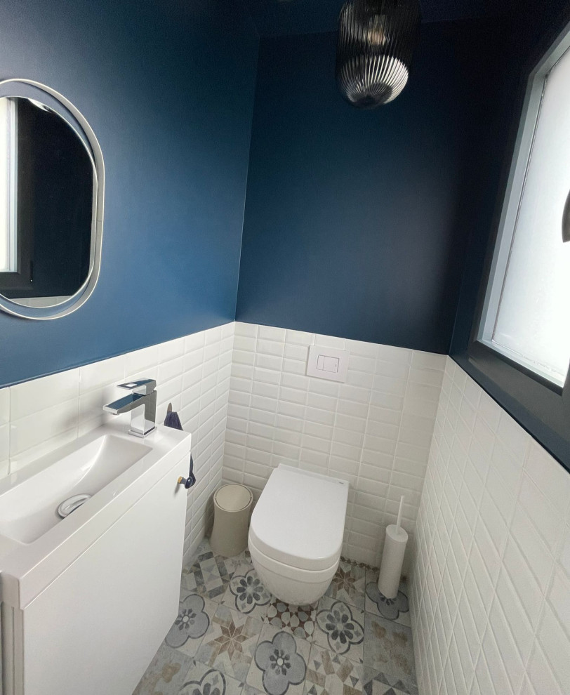 Idéer för ett mellanstort 60 tals toalett, med vita skåp, en vägghängd toalettstol, vit kakel, tunnelbanekakel, blå väggar, klinkergolv i keramik, ett väggmonterat handfat och blått golv