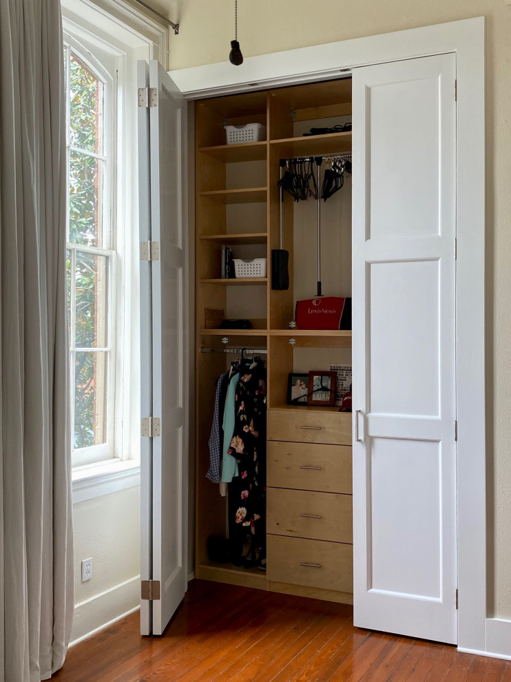Inspiration for a mid-sized contemporary built-in wardrobe in New Orleans with light wood cabinets.