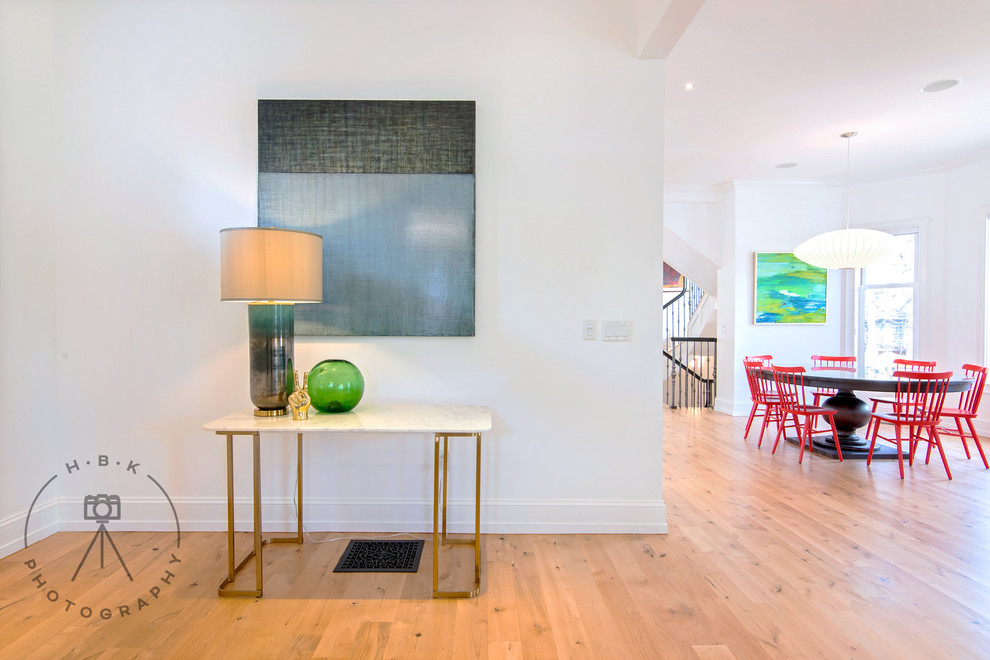 Large light wood floor and beige floor foyer photo with white walls