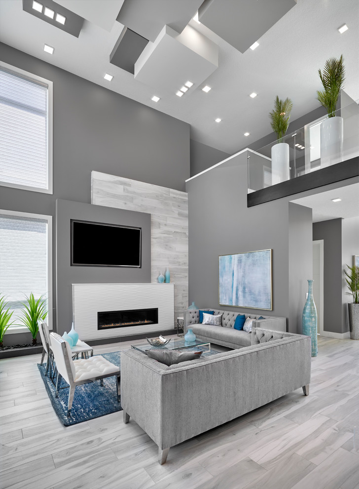 Photo of a large contemporary open concept living room in Edmonton with grey walls, porcelain floors, a ribbon fireplace, a tile fireplace surround, a built-in media wall and grey floor.