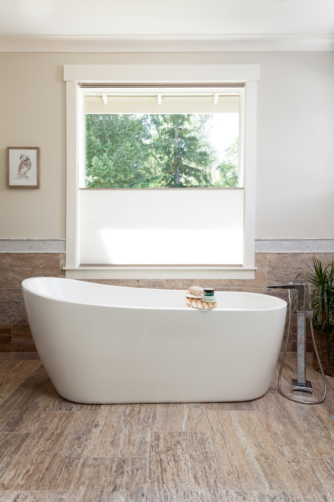Inspiration for a large transitional master bathroom in Seattle with shaker cabinets, grey cabinets, a freestanding tub, an alcove shower, a two-piece toilet, multi-coloured tile, brown tile, travertine, grey walls, travertine floors, an undermount sink, marble benchtops, a hinged shower door and brown floor.