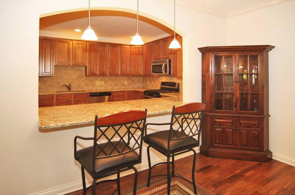 Kitchen - medium tone wood floor kitchen idea in Indianapolis with shaker cabinets, medium tone wood cabinets, granite countertops, stainless steel appliances and an island