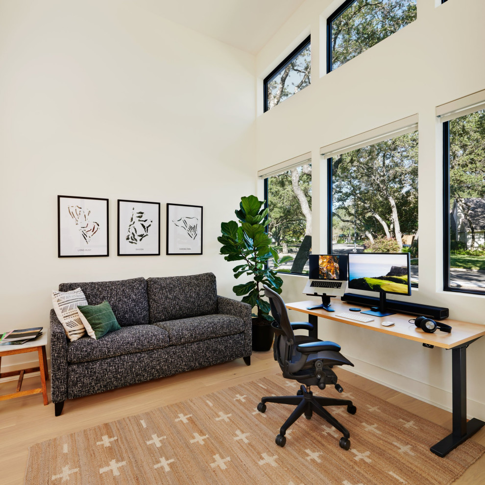 Diseño de despacho vintage de tamaño medio con paredes blancas, suelo de madera clara y escritorio independiente