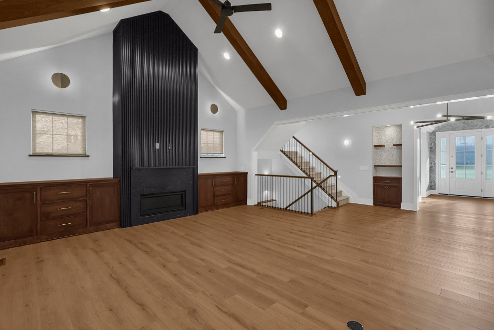 Transitional open concept vaulted ceiling home design photo in Columbus with a standard fireplace and a wood fireplace surround