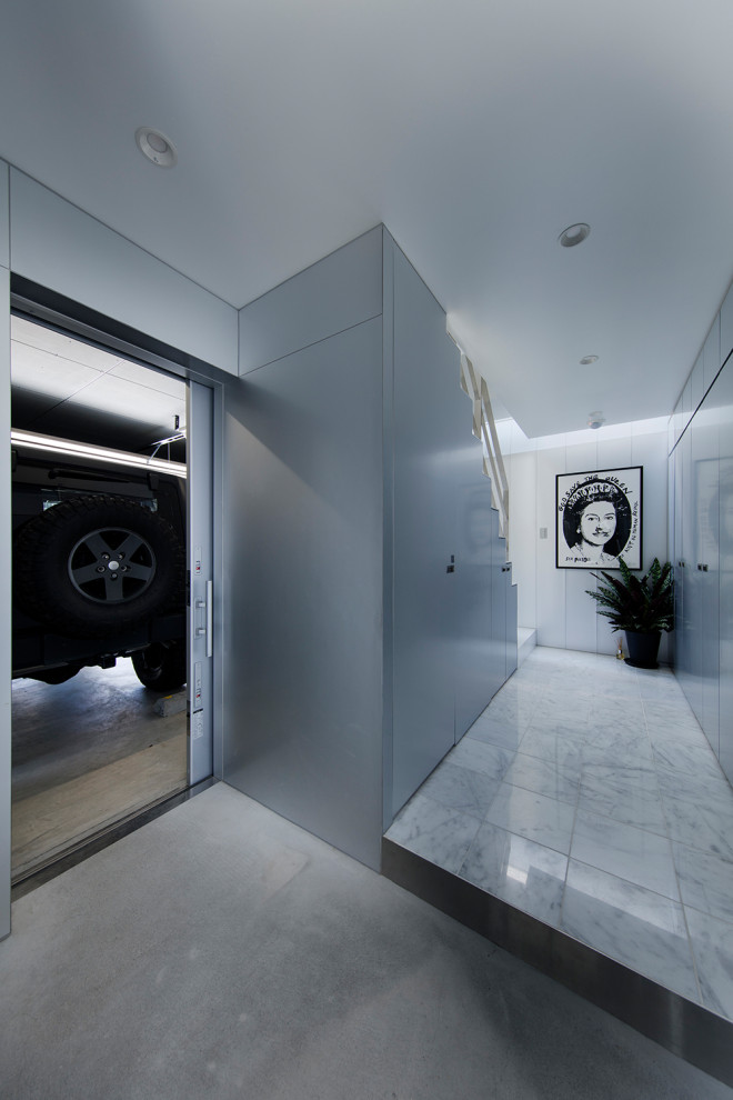 Foto de hall blanco minimalista pequeño con paredes metalizadas, suelo de cemento, puerta corredera, puerta metalizada, suelo gris, machihembrado y panelado