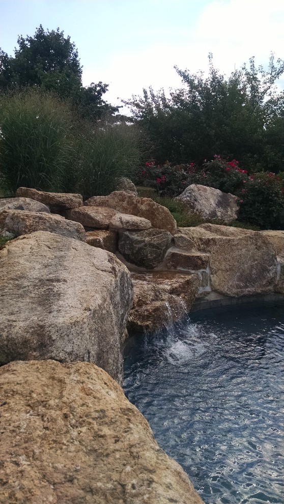 Example of a mountain style backyard custom-shaped pool design in New York