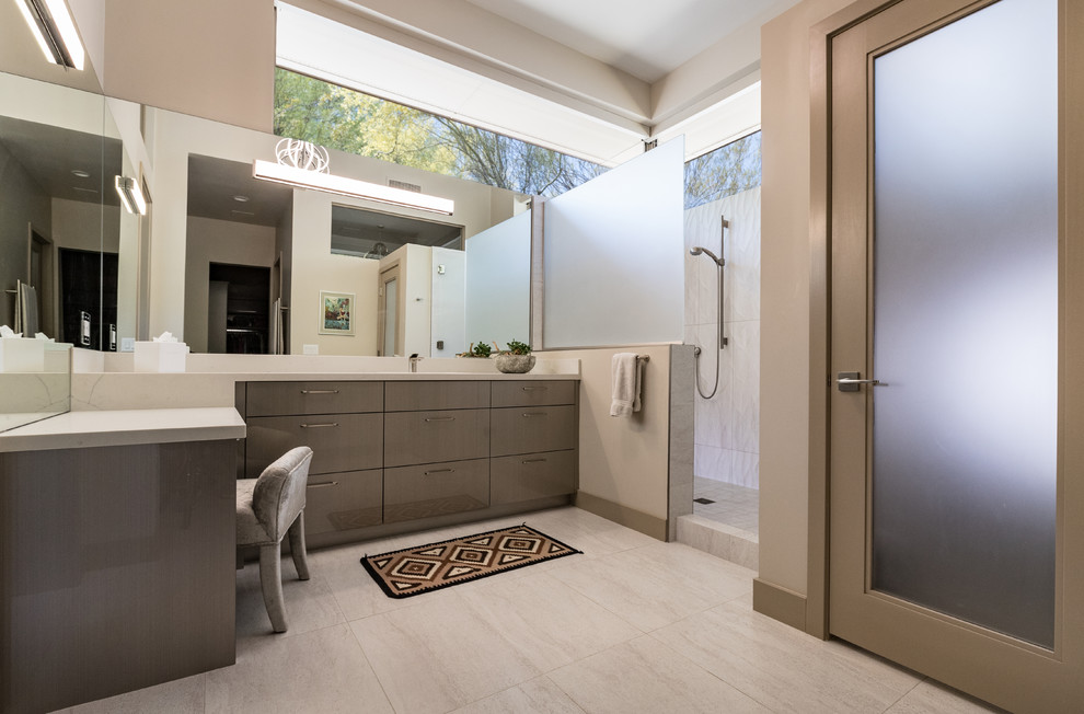Design ideas for a mid-sized contemporary master wet room bathroom in Phoenix with flat-panel cabinets, grey cabinets, a japanese tub, white tile, porcelain tile, beige walls, porcelain floors, an undermount sink, engineered quartz benchtops, grey floor, a hinged shower door, white benchtops and a one-piece toilet.