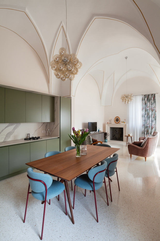 Immagine di una sala da pranzo minimal con pareti beige, camino classico, cornice del camino in pietra, pavimento multicolore e soffitto a volta