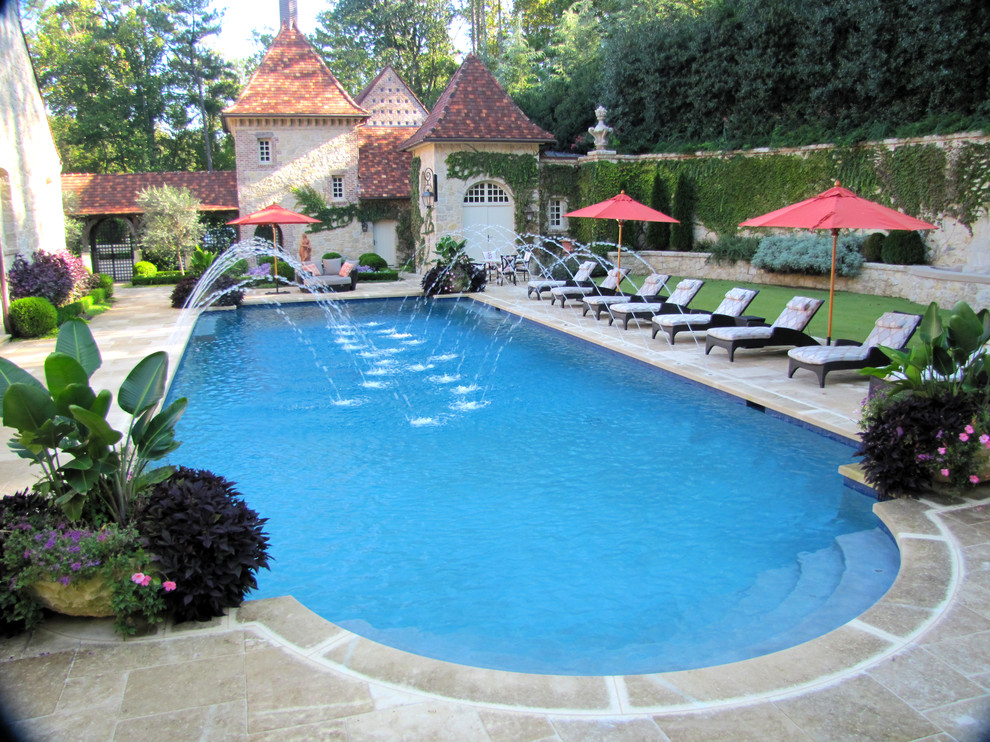 Photo of a large mediterranean backyard rectangular natural pool in Atlanta with natural stone pavers.