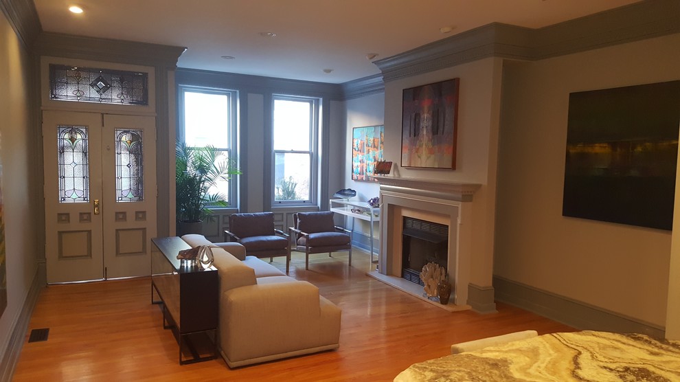 This is an example of a small traditional formal open concept living room in Philadelphia with white walls, medium hardwood floors, a standard fireplace, a stone fireplace surround, no tv and brown floor.