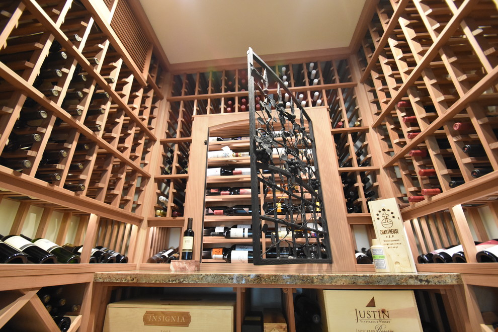 This is an example of a mid-sized scandinavian wine cellar in Orange County with ceramic floors, display racks and beige floor.