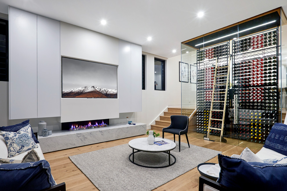 This is an example of a contemporary open concept living room in Sydney with white walls and laminate floors.