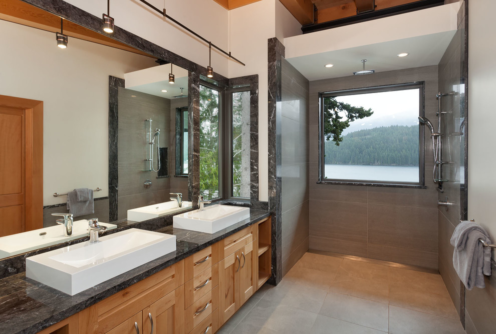Photo of a large contemporary master bathroom in Vancouver with shaker cabinets, medium wood cabinets, a curbless shower, gray tile, stone tile, white walls, slate floors, a vessel sink and granite benchtops.