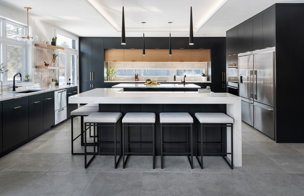 Large contemporary u-shaped kitchen in Ottawa with a submerged sink, flat-panel cabinets, black cabinets, engineered stone countertops, beige splashback, window splashback, stainless steel appliances, grey floors, white worktops, a drop ceiling and multiple islands.