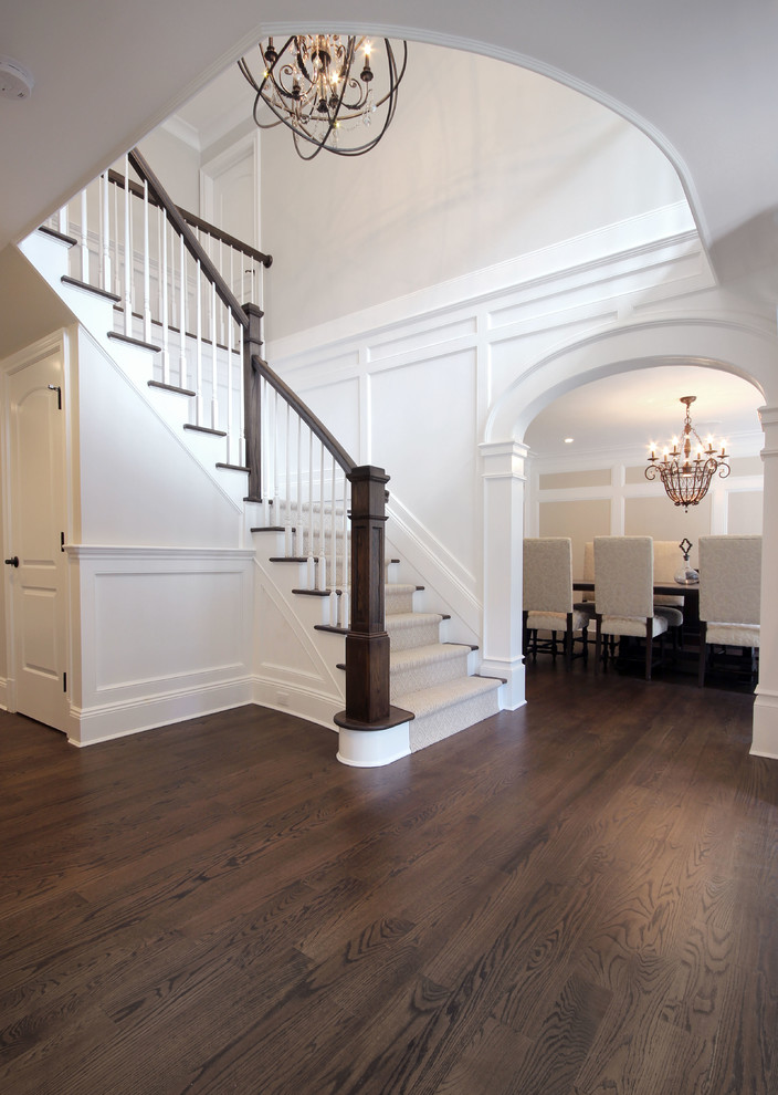 Design ideas for a mid-sized transitional foyer in New York with beige walls, dark hardwood floors and brown floor.
