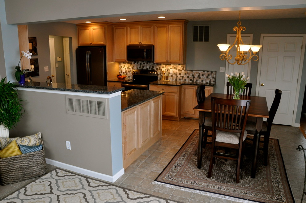 Mid-sized transitional l-shaped ceramic tile eat-in kitchen photo in Cincinnati with an undermount sink, recessed-panel cabinets, light wood cabinets, granite countertops, gray backsplash, glass sheet backsplash, stainless steel appliances and a peninsula