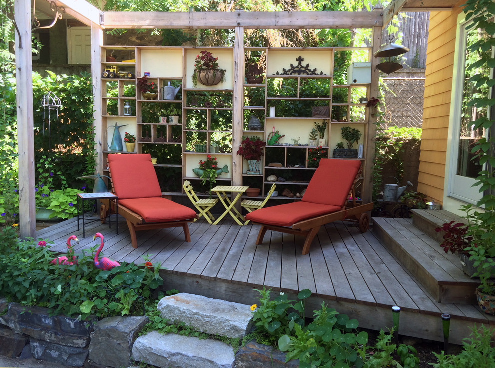 Inspiration for a small eclectic backyard deck in Boston with a container garden and a pergola.
