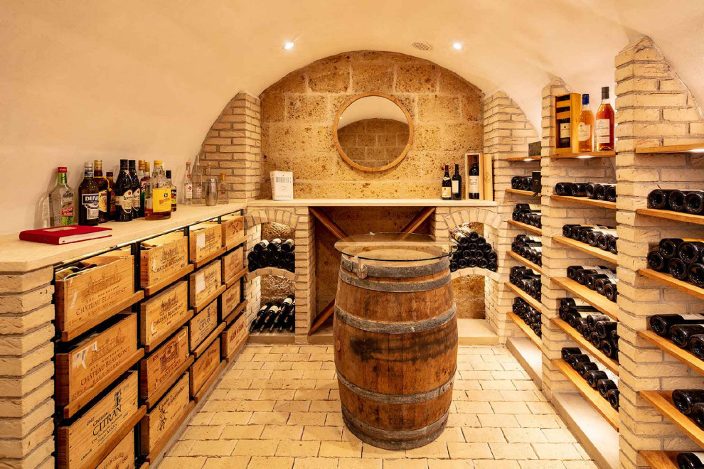 Idée de décoration pour une cave à vin tradition de taille moyenne avec un sol en brique, un présentoir et un sol beige.