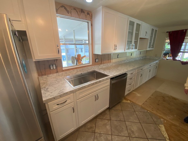 Example of a large galley eat-in kitchen design with shaker cabinets, white cabinets, laminate countertops, a peninsula and white countertops