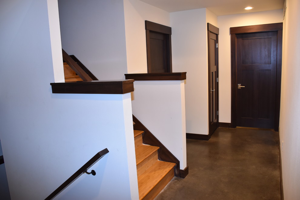 Inspiration for a mid-sized asian hallway in Milwaukee with white walls, concrete floors and brown floor.