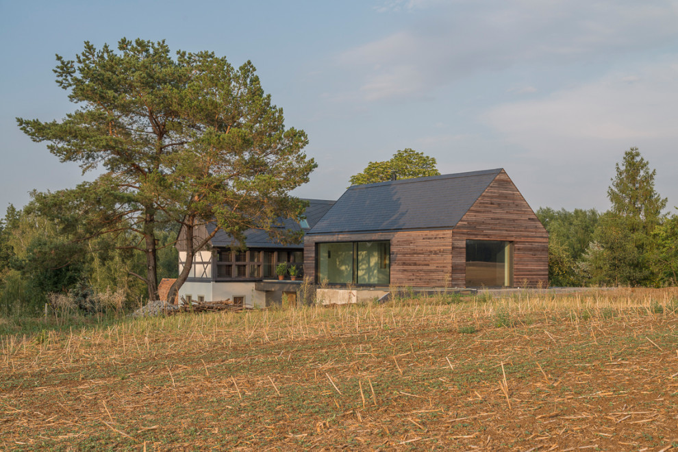 Идея дизайна: деревянный, коричневый дом среднего размера в современном стиле с серой крышей