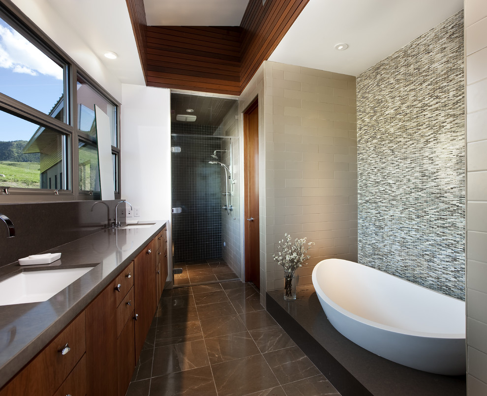 This is an example of a mid-sized contemporary master bathroom in Los Angeles with dark wood cabinets, a freestanding tub, an alcove shower, flat-panel cabinets, green tile, mosaic tile, beige walls, marble floors, an undermount sink and engineered quartz benchtops.