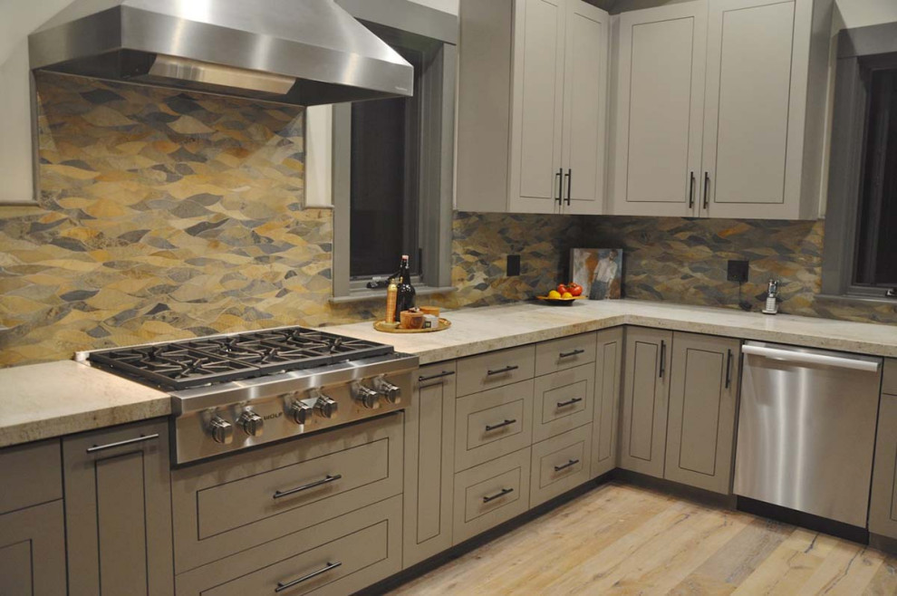 Bild på ett mellanstort vintage beige beige kök, med en nedsänkt diskho, släta luckor, grå skåp, bänkskiva i kvartsit, flerfärgad stänkskydd, stänkskydd i skiffer, rostfria vitvaror, mellanmörkt trägolv, en köksö och brunt golv