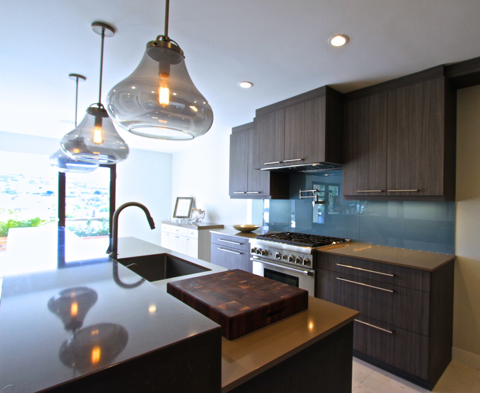 Mid-sized trendy l-shaped ceramic tile eat-in kitchen photo in Orange County with an undermount sink, flat-panel cabinets, dark wood cabinets, laminate countertops, blue backsplash, glass sheet backsplash, stainless steel appliances and an island