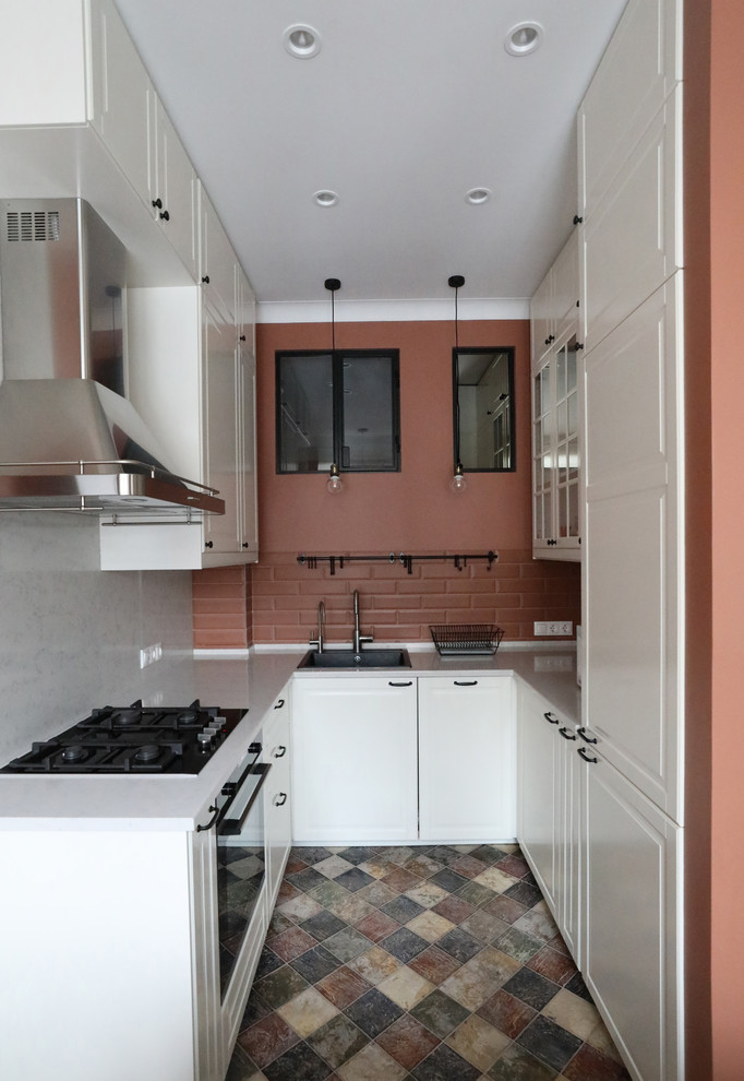 Design ideas for a small contemporary u-shaped eat-in kitchen in Moscow with a drop-in sink, white cabinets, quartz benchtops, terra-cotta splashback, ceramic floors, no island, multi-coloured floor, white benchtop, raised-panel cabinets, brown splashback and black appliances.