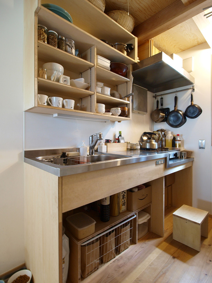 Small asian single-wall kitchen in Other with a single-bowl sink, open cabinets, brown cabinets, stainless steel benchtops, medium hardwood floors and brown floor.