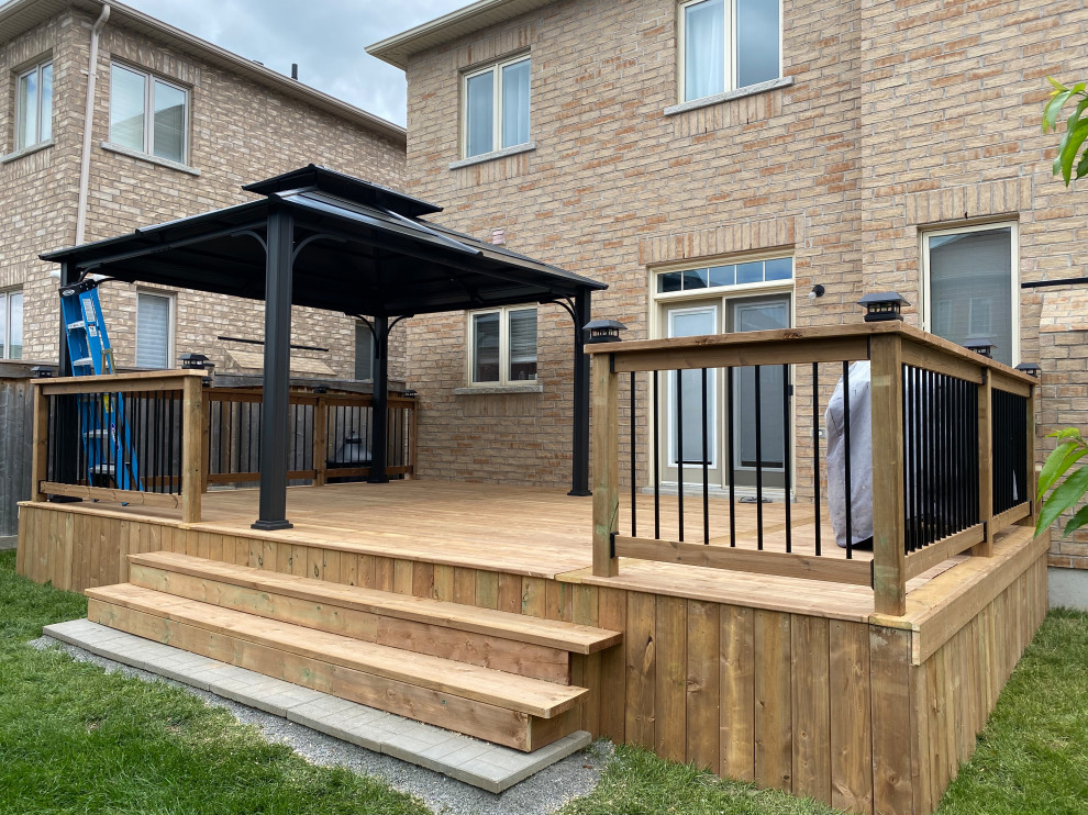 Photo of a large traditional back first floor metal railing terrace in Toronto with a potted garden and a pergola.