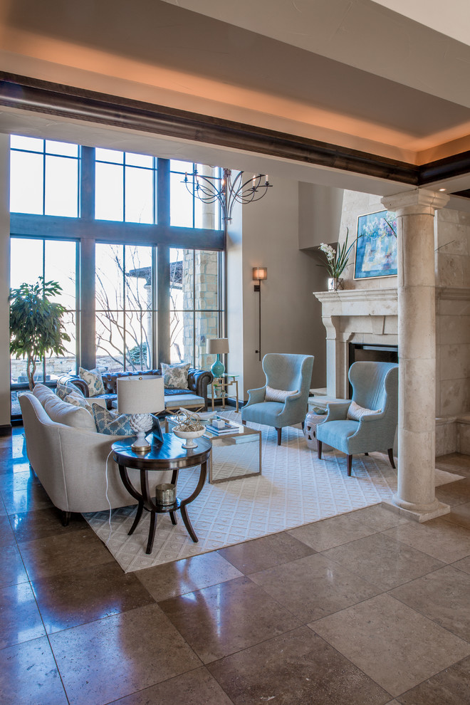 Photo of an expansive traditional open concept living room in Denver with beige walls, limestone floors, a standard fireplace, a stone fireplace surround and beige floor.