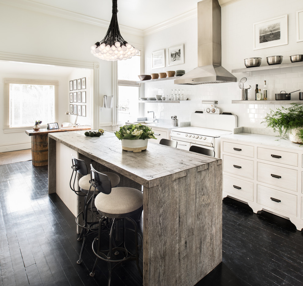 Photo of a mid-sized transitional single-wall kitchen in San Francisco with an undermount sink, with island, flat-panel cabinets, light wood cabinets, marble benchtops, white splashback, ceramic splashback, stainless steel appliances and dark hardwood floors.