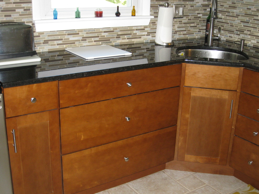 Eat-in kitchen - transitional u-shaped travertine floor and beige floor eat-in kitchen idea in Boston with an undermount sink, medium tone wood cabinets, granite countertops, stainless steel appliances, a peninsula, shaker cabinets, brown backsplash, matchstick tile backsplash and black countertops