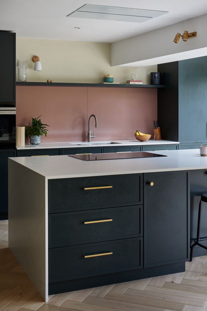 Inspiration for a large contemporary l-shaped eat-in kitchen in Kent with recessed-panel cabinets, green cabinets, quartz benchtops, pink splashback, glass sheet splashback, stainless steel appliances, with island and white benchtop.