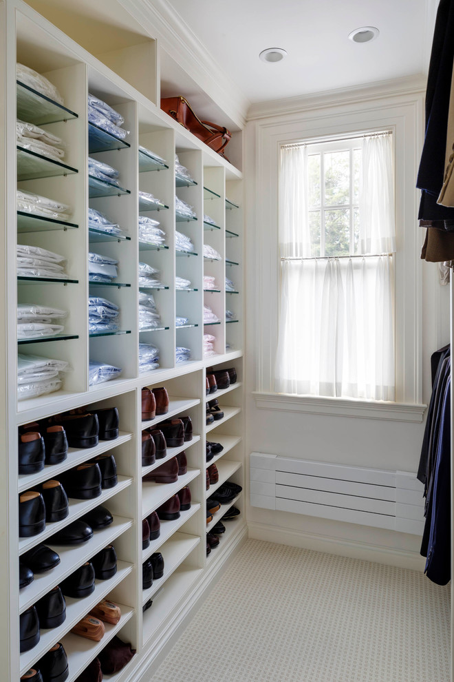 Inspiration for a mid-sized traditional gender-neutral walk-in wardrobe in Boston with white cabinets, carpet, beige floor and open cabinets.