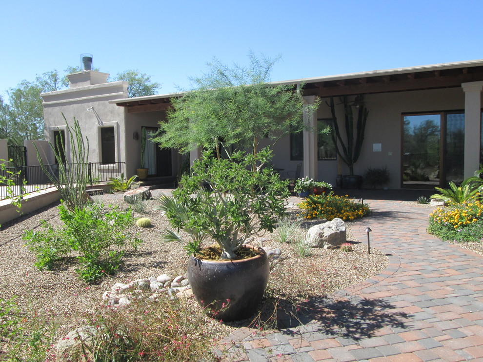 Inspiration for a mid-sized mediterranean backyard full sun xeriscape for summer in Phoenix with a garden path and brick pavers.