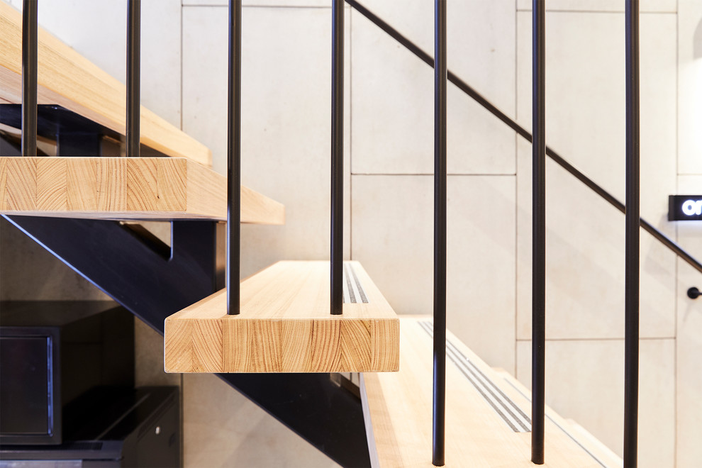 Inspiration for an expansive industrial wood u-shaped staircase in Melbourne with open risers and metal railing.