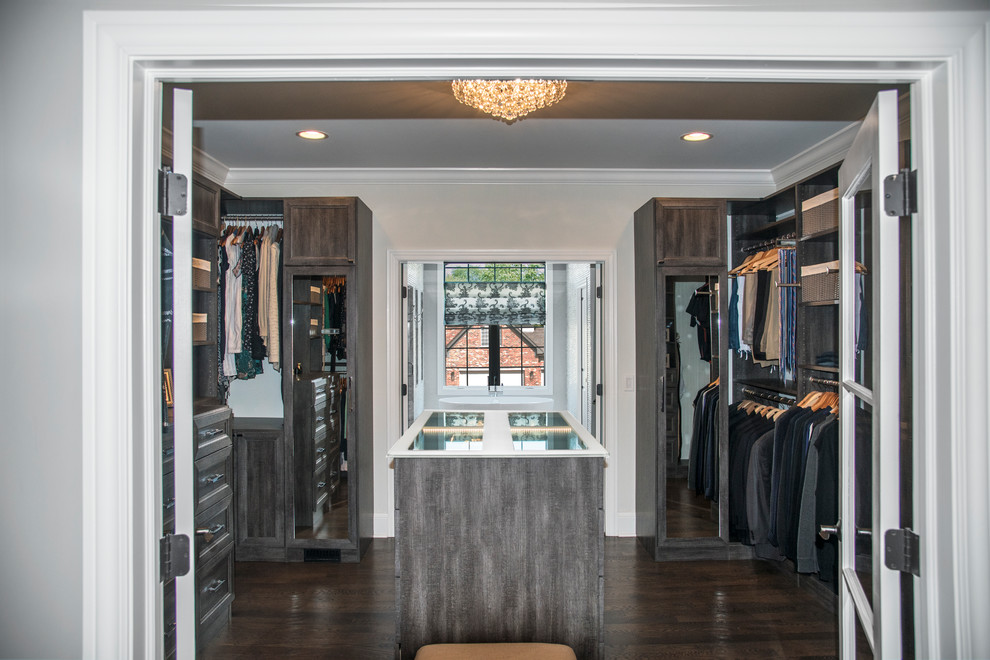 Inspiration for a mid-sized transitional gender-neutral walk-in wardrobe in Chicago with recessed-panel cabinets, distressed cabinets, dark hardwood floors and brown floor.