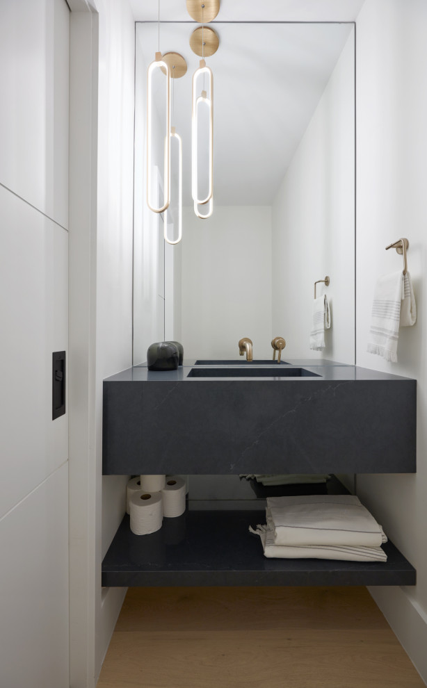 Kleine Moderne Gästetoilette mit grauen Schränken, weißer Wandfarbe, hellem Holzboden, integriertem Waschbecken, Quarzwerkstein-Waschtisch, grauer Waschtischplatte und schwebendem Waschtisch in Toronto