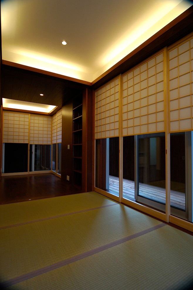 Asian master bedroom in Tokyo with tatami floors, brown walls, no fireplace and green floor.