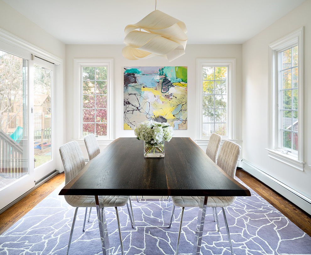 This is an example of a transitional dining room in New York with beige walls and medium hardwood floors.
