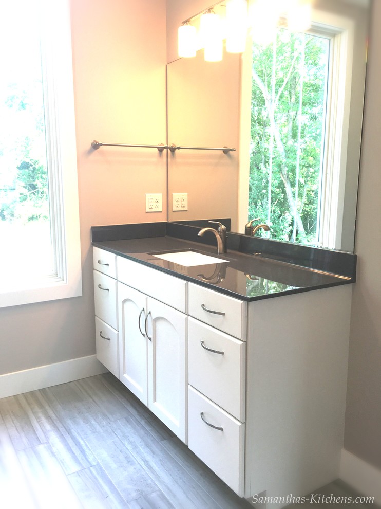 Example of a mid-sized transitional 3/4 porcelain tile home design design with recessed-panel cabinets, white cabinets, beige walls, an integrated sink and marble countertops