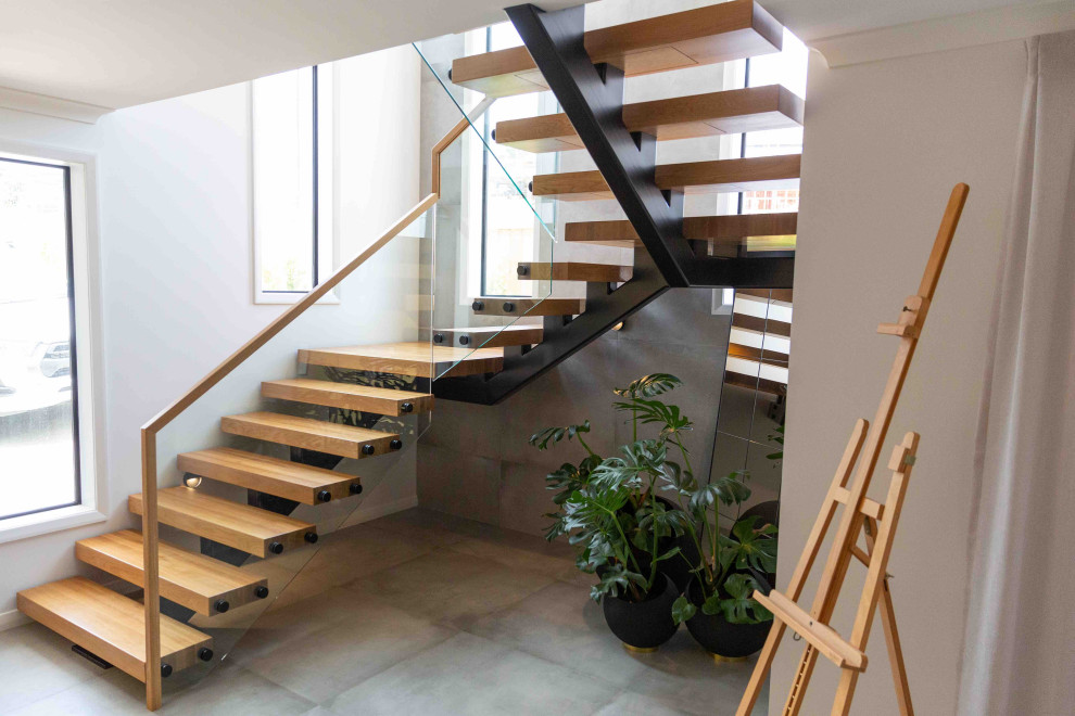 Design ideas for a medium sized modern wood floating wood railing staircase in Auckland with open risers.