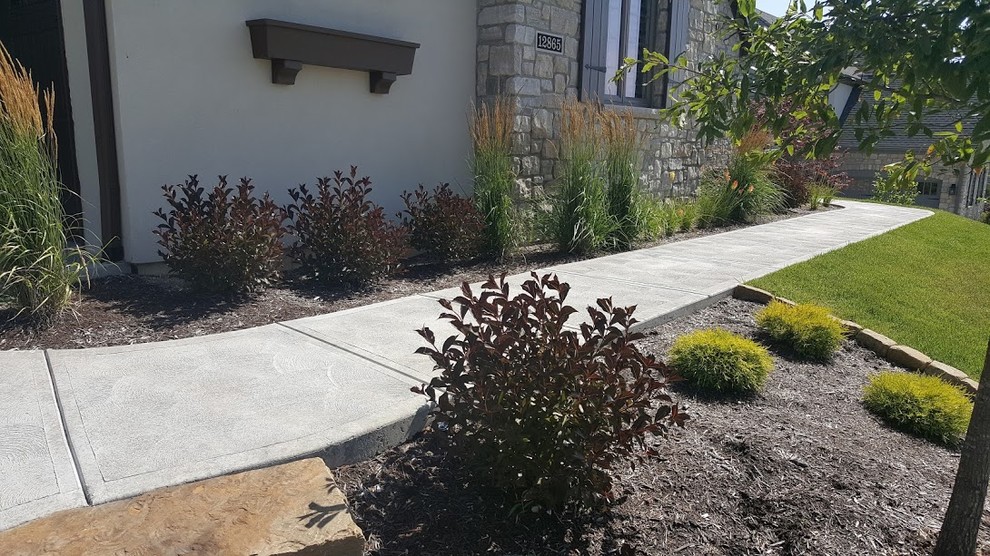 Photo of a mid-sized transitional front yard full sun formal garden for summer in St Louis with a garden path and natural stone pavers.