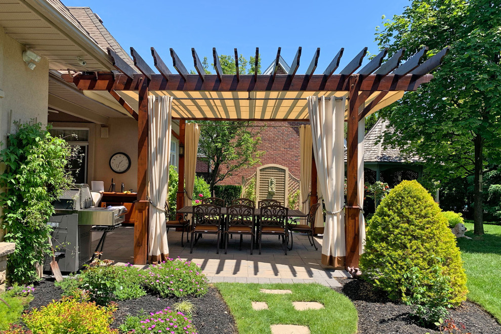Photo of a traditional backyard patio in Toronto with concrete pavers and a pergola.