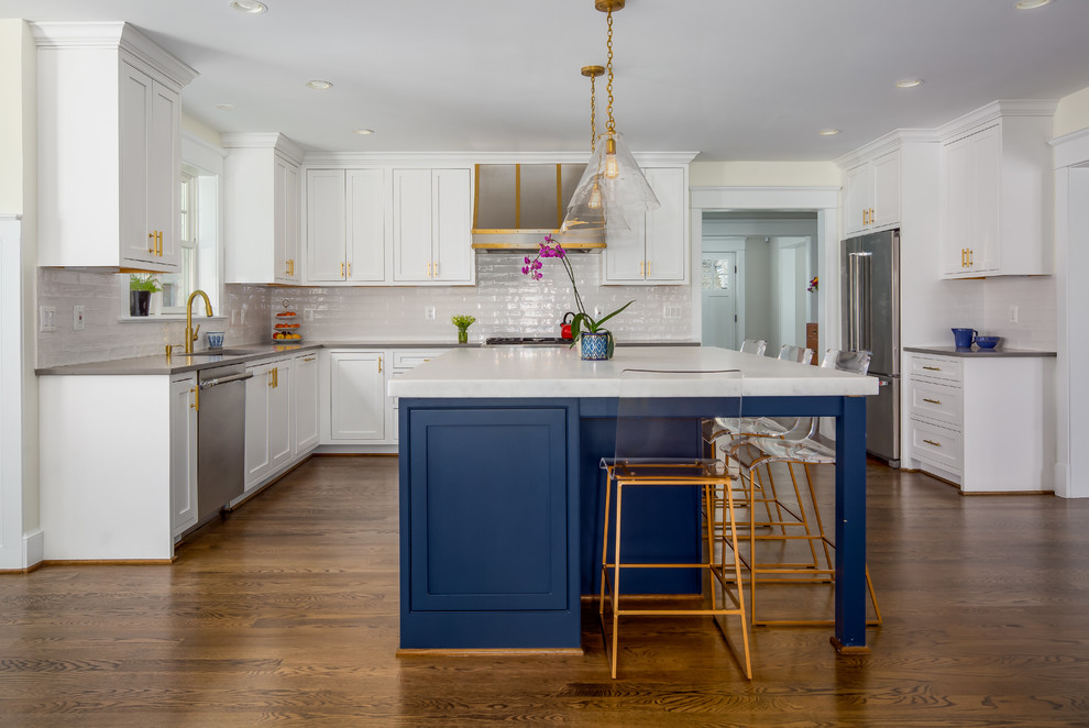 Design ideas for a transitional u-shaped kitchen in DC Metro with an undermount sink, beaded inset cabinets, white cabinets, white splashback, stainless steel appliances, dark hardwood floors, with island, brown floor and white benchtop.